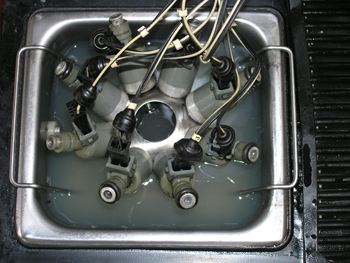 this shows a set of fuel injectors being cleaned in the ultrasonic cleaning tank. 