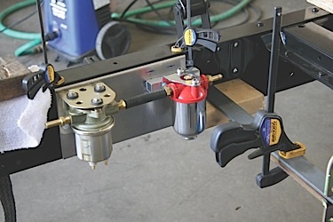 the fuel filter and electric fuel pump are mounted together on a fabricated aluminum mount that bolts onto stock bolt holes located inside the frame.