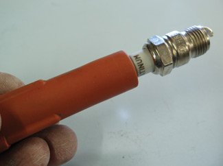 Photo 5: Using a spare spark plug boot or length of fuel hose to handle the spark plug during preparation and installation can prevent contaminating the spark plug insulator with greasy fingerprints. 