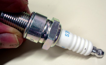 grasping a spark plug by its threads will prevent contaminating the insulator with greasy fingerprints.