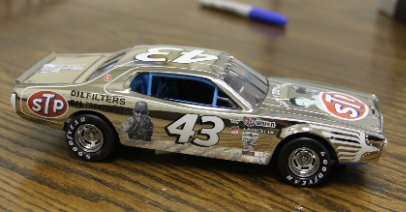 Paul DeSantis and Brian Pallerino made this custom 1:24 scale Dodge Charger as a birthday gift for NASCAR Hall of Famer Richard Petty. The hand-built model features a one-of-a-kind chrome paint scheme with retro sponsorship decals, throwback Petty photos and “Happy Birthday” messages on the hood and bumper.