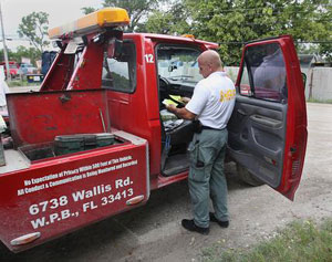 After the Palm Beach County Sheriff’s Office issued a warrant at King's Wrecker Service located at 6738 Wallis Road in West Palm Beach, Deputy Sheriff Kurt Kloepping searches a tow truck for evidence of illegal towing practices. Deputies say that numerous complaints have been made to the Better Business Bureau regarding the company's operations. Photo by Damon Higgins/The Palm Beach Post.