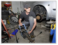 John Brederson, of John-John's Automotive, repairs a car in his lower County Street shop. (Staff photo by Tom Maguire)